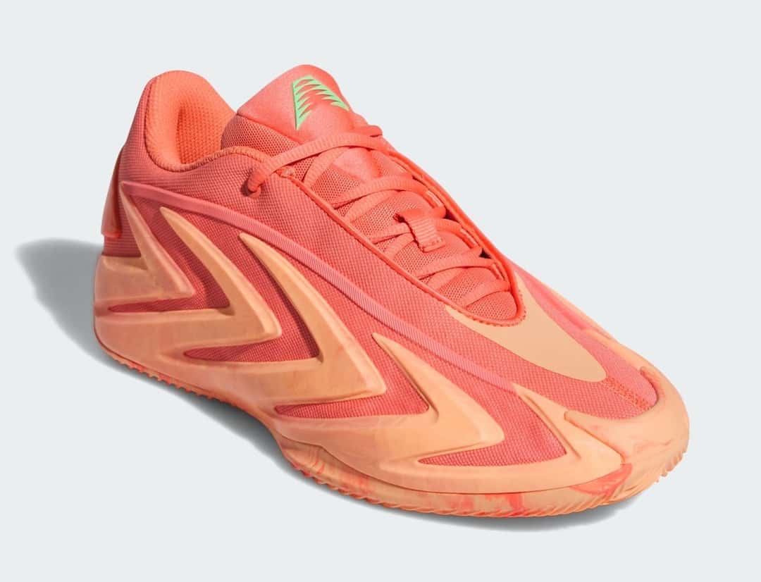 adidas AE 3 With Love en vista tres cuartos, con la capellada coral y las flechas color durazno en relieve