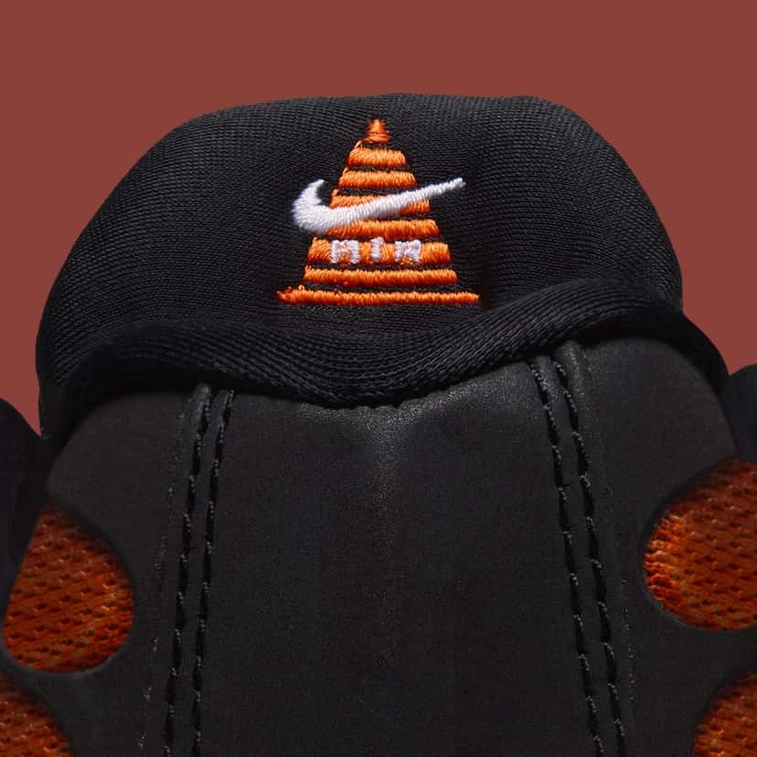 Detalle del cono naranja bordado con el Swoosh blanco y la palabra Air en el interior de la lengüeta de la Nike Air Max Plus «Glasgow»
