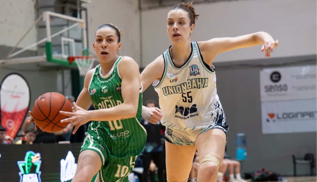 Una jugadora de El Biguá, con camiseta verde a rayas, avanza con la pelota ante una rival de Unión Bahía, de blanco, en Neuquén