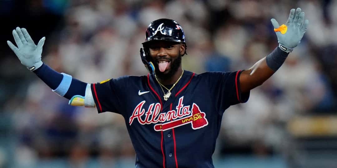Michael Harris II, de los Braves, con casco y camiseta azul de Atlanta, festeja con los brazos abiertos y la lengua afuera en Dodger Stadium