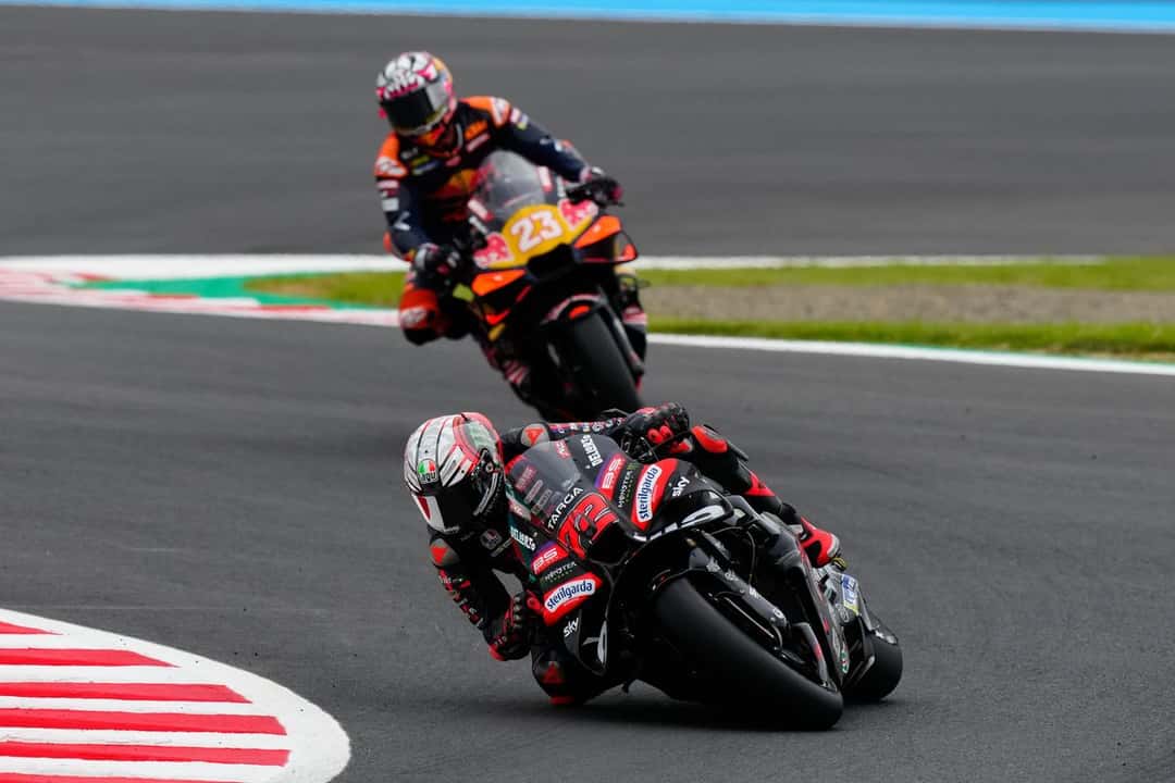 Marco Bezzecchi, con la Aprilia negra número 72, encara una curva de Motegi seguido por Enea Bastianini con la KTM número 23