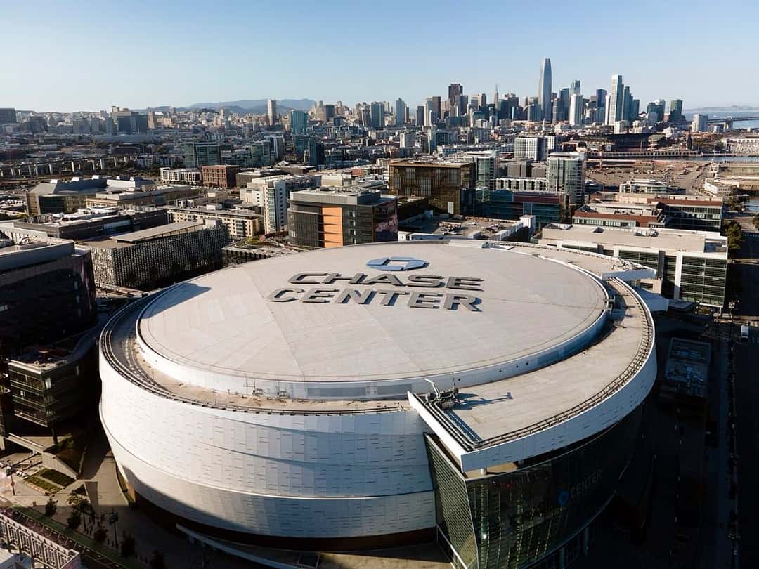 Vista aérea del Chase Center, el estadio de los Golden State Warriors, con su techo blanco y el centro de San Francisco de fondo