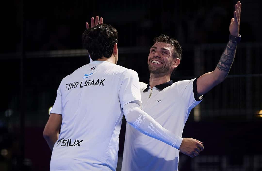 Foto de archivo: Tino Libaak, de espaldas con su nombre en la remera blanca, se abraza con Gonzalo Alfonso, que sonríe y levanta el brazo en una cancha techada