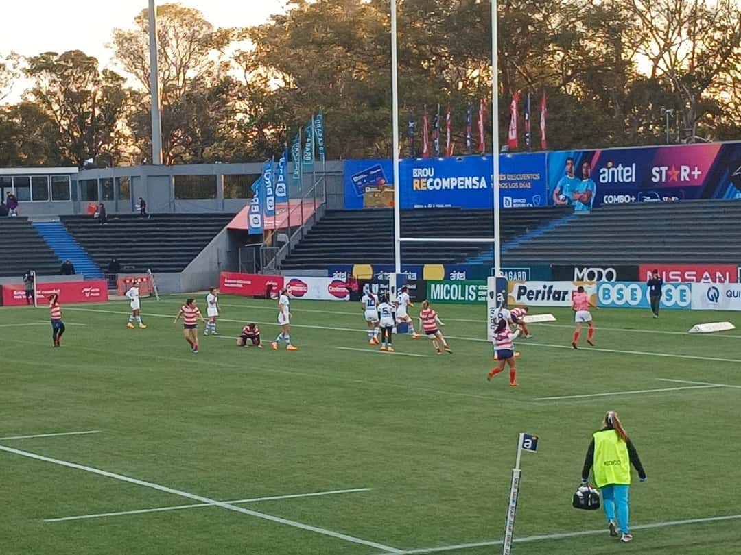 Imagen de referencia: un partido de seven femenino en el Estadio Charrúa de Montevideo, con las tribunas y los carteles al fondo al atardecer