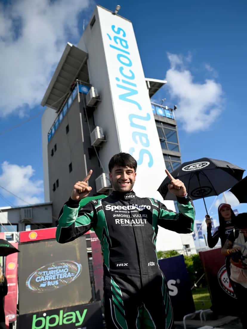 Ignacio Faín, con el buzo del equipo, festeja con los dedos en alto debajo de la torre del autódromo de San Nicolás tras lograr la pole del sábado (foto de archivo del fin de semana)