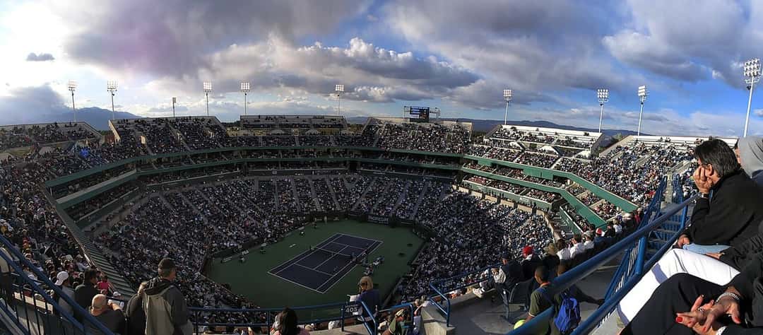 Foto de archivo: vista panorámica del estadio principal de Indian Wells, con las tribunas llenas y la cancha azul en el centro bajo un cielo con nubes