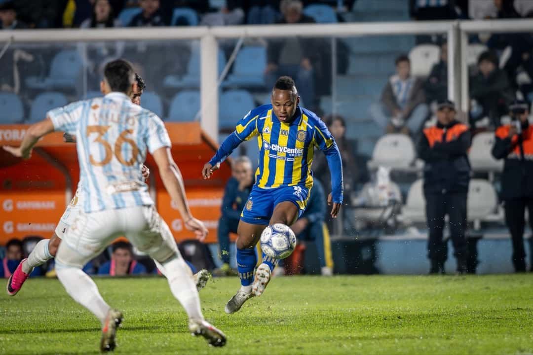 Un jugador de Rosario Central, de azul y amarillo, conduce la pelota ante un defensor de Atlético Tucumán con la camiseta celeste y blanca número 36 (foto: Liga Profesional de Fútbol)