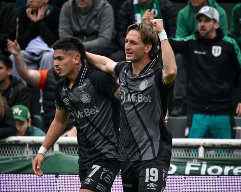 Dos jugadores de Argentinos Juniors, con la camiseta negra y gris, festejan abrazados durante el partido ante Banfield en el Florencio Sola (foto: Liga Profesional de Fútbol)