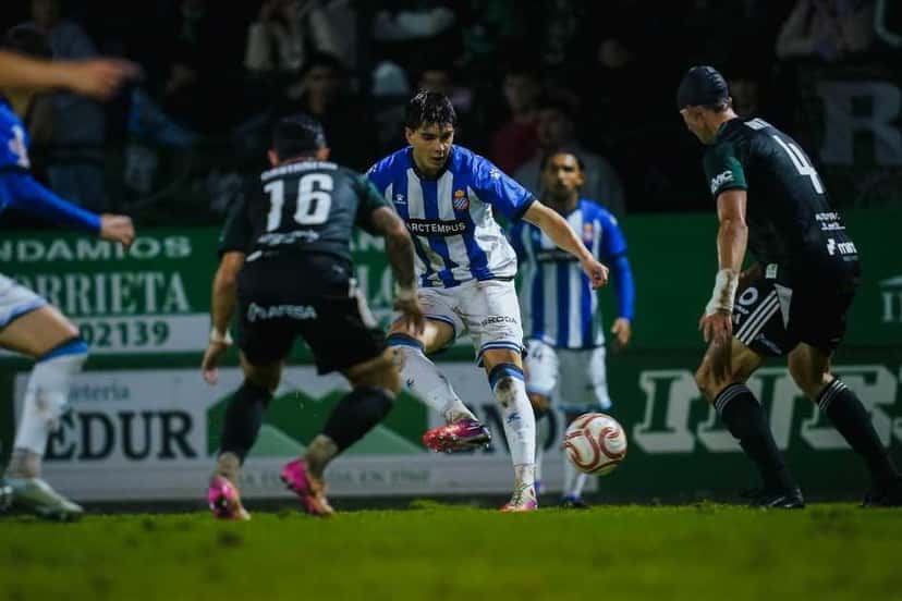 Un jugador del Espanyol, con la camiseta blanca y azul, avanza con la pelota entre tres futbolistas del Sestao River, de negro y verde, en el partido de la Copa del Rey en el estadio Las Llanas, el martes 27 de octubre de 2026 (foto: prensa RCD Espanyol)