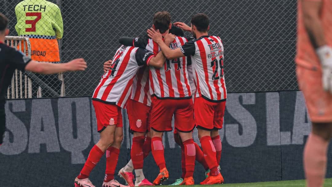 Los jugadores de Barracas Central, con la camiseta a rayas rojas y blancas, se abrazan en el festejo de un gol ante Huracán en el estadio Claudio Chiqui Tapia (foto: prensa Barracas Central)
