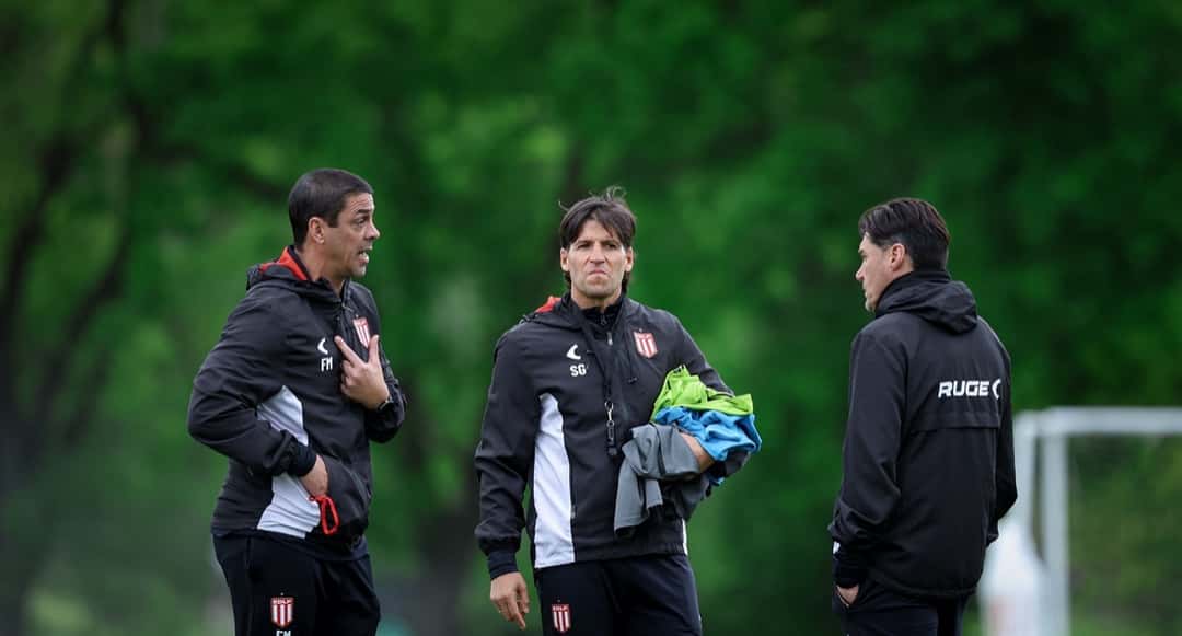 Alexander Medina, entrenador de Estudiantes, con campera negra del club, conversa con dos colaboradores durante un entrenamiento; foto de archivo (foto: prensa Estudiantes de La Plata)