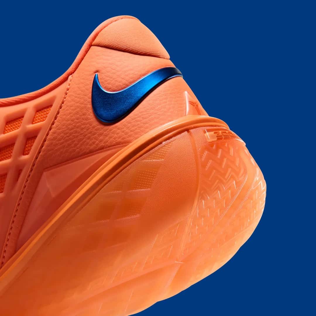 Detalle del talón de la Nike Kobe 3 Low Protro Arancia, con el Swoosh azul metalizado y la suela naranja translúcida