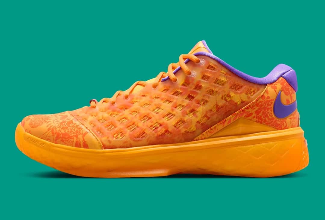 Nike Kobe 3 Low Protro Mamba Eterno de perfil sobre fondo verde agua, con jaula translúcida naranja sobre un estampado floral rojo, cordones naranjas, swoosh violeta en el talón, cuello violeta y suela naranja