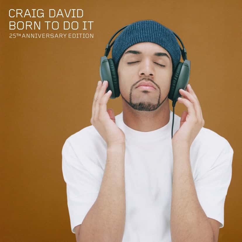Portada de la edición del 25.º aniversario de «Born To Do It»: Craig David con gorro azul y auriculares, de ojos cerrados, sobre fondo ocre