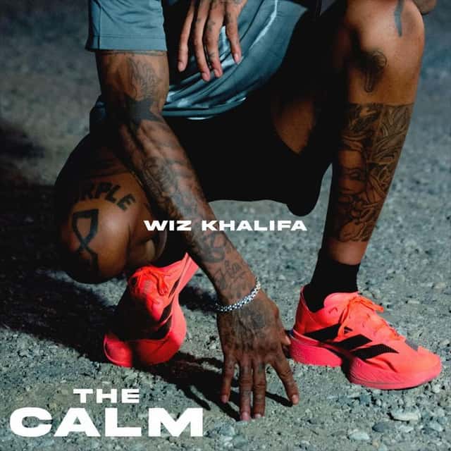 Portada del single «The Calm», de Wiz Khalifa: el rapper agachado sobre el asfalto, con zapatillas naranjas y tatuajes en los brazos, con el título en letras blancas