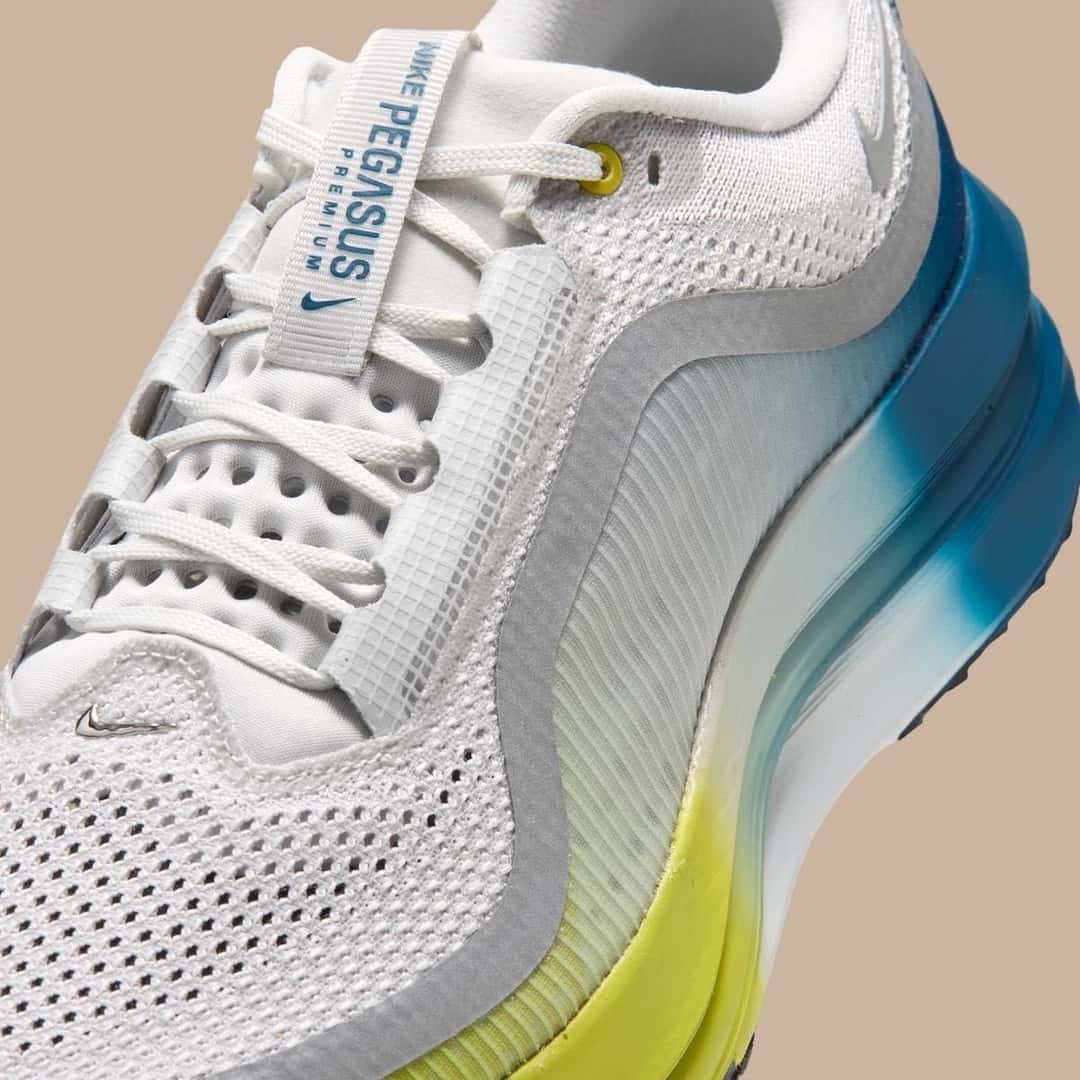 Detalle de la Nike Pegasus Premium Perfect Texture for Running con la etiqueta de la lengüeta y la mediasuela en degradé de azul a amarillo
