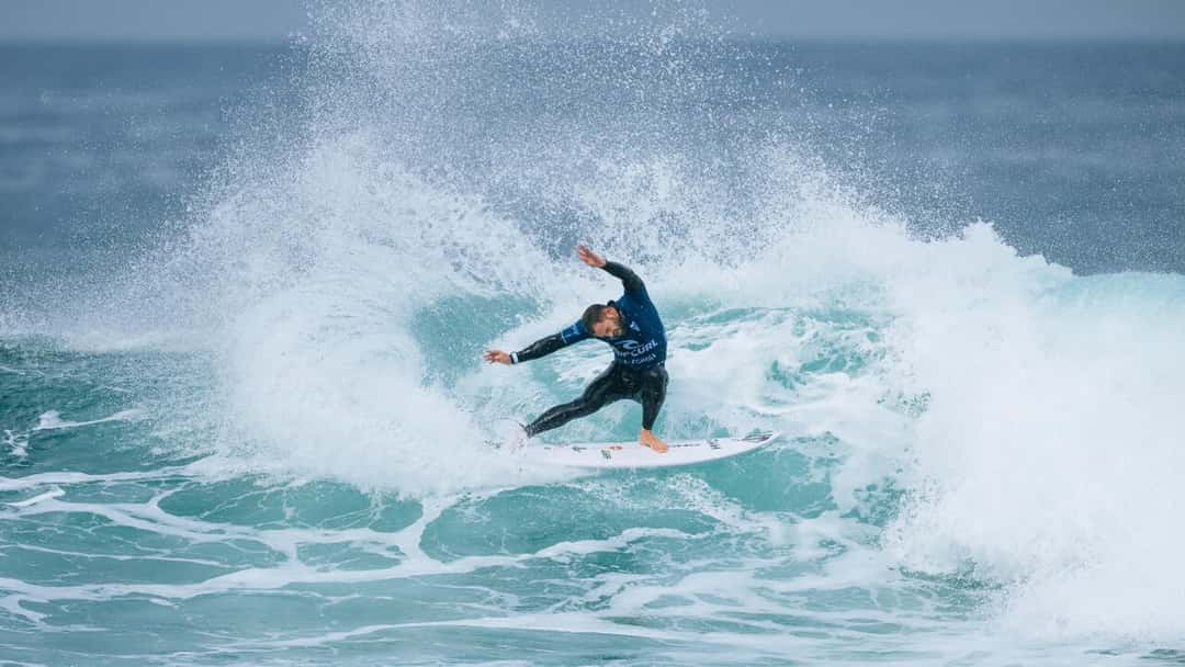 Alejo Muniz, con la lycra azul de Rip Curl, hace un giro sobre la ola y levanta una pared de agua y espuma (foto de archivo)