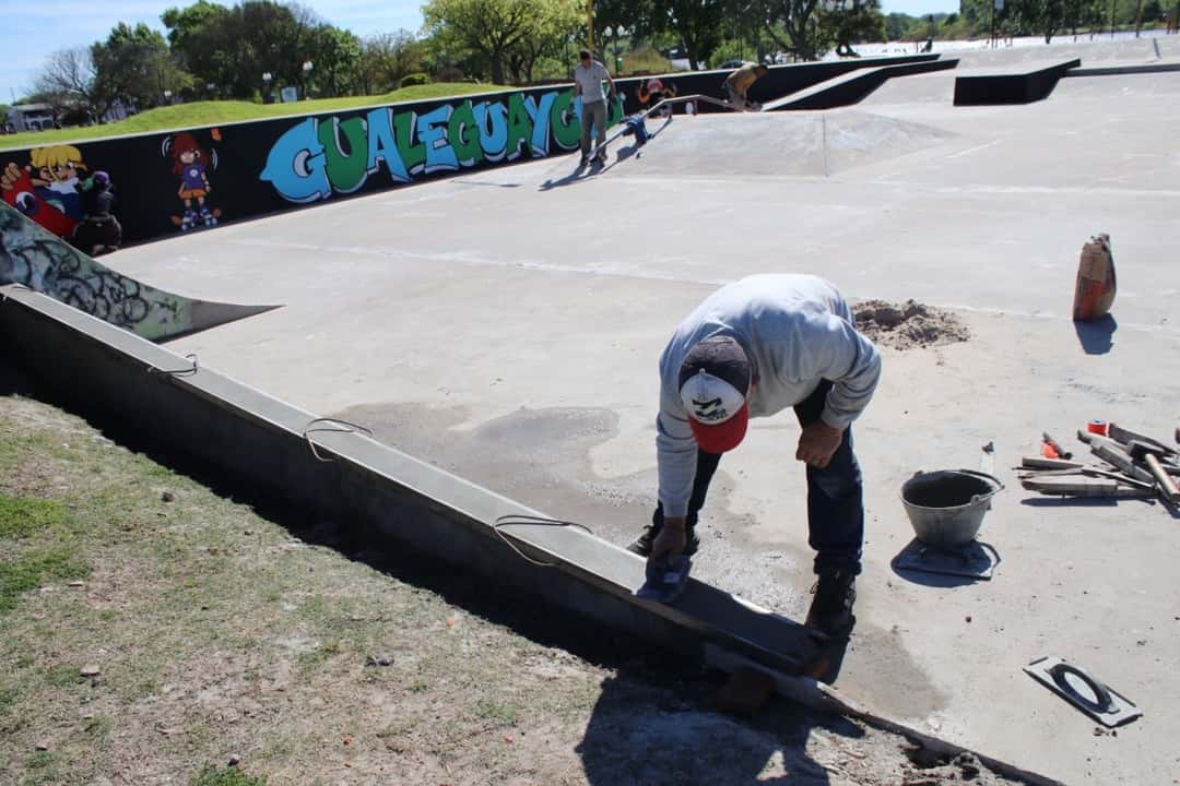 Un operario termina a mano, con una llana, el borde de hormigón del skatepark de Gualeguaychú, junto al mural con el nombre de la ciudad