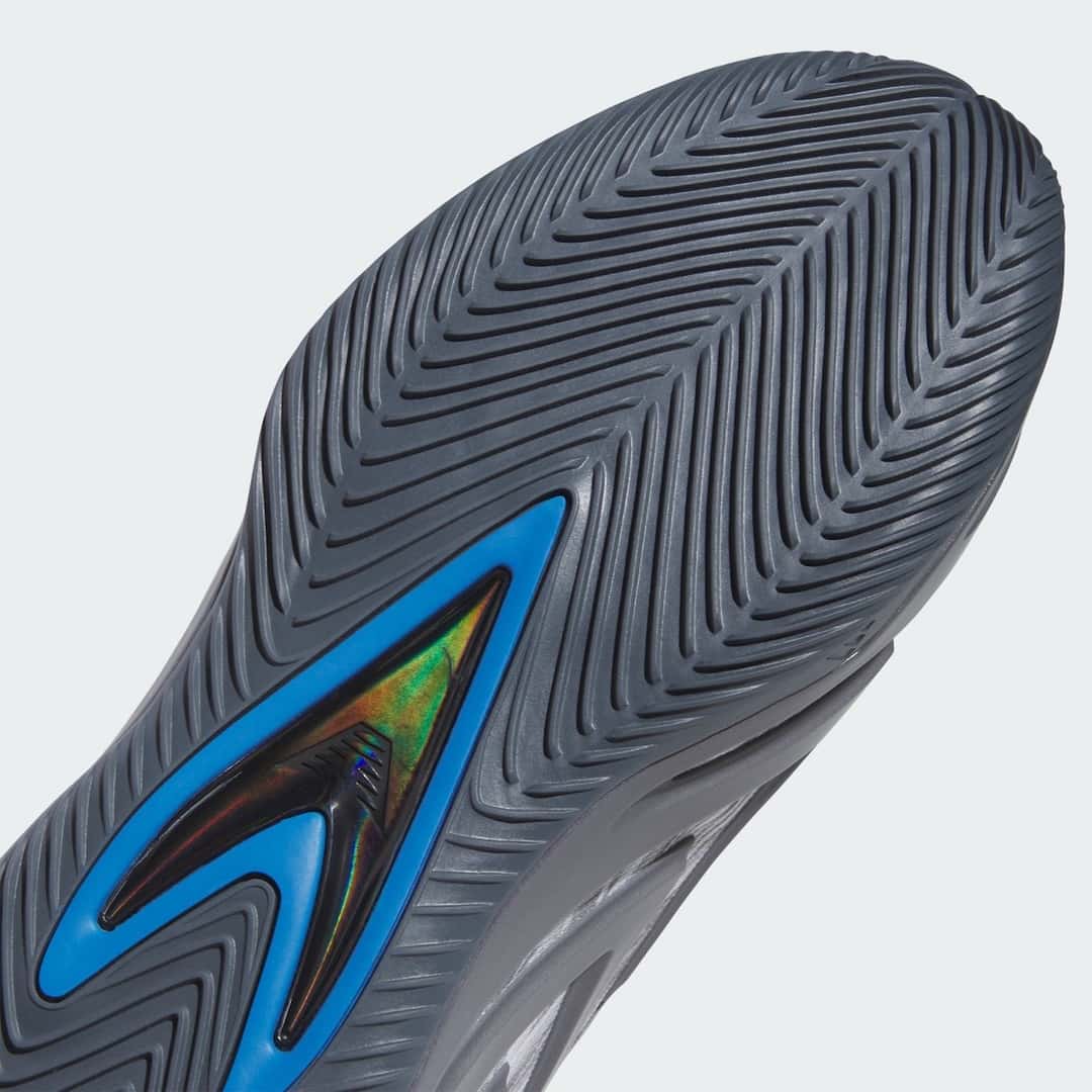 Detalle de la suela del adidas Anthony Edwards 3 Snow Camo, con tracción en espiga gris oscura y la pieza central con borde azul y reflejos tornasolados