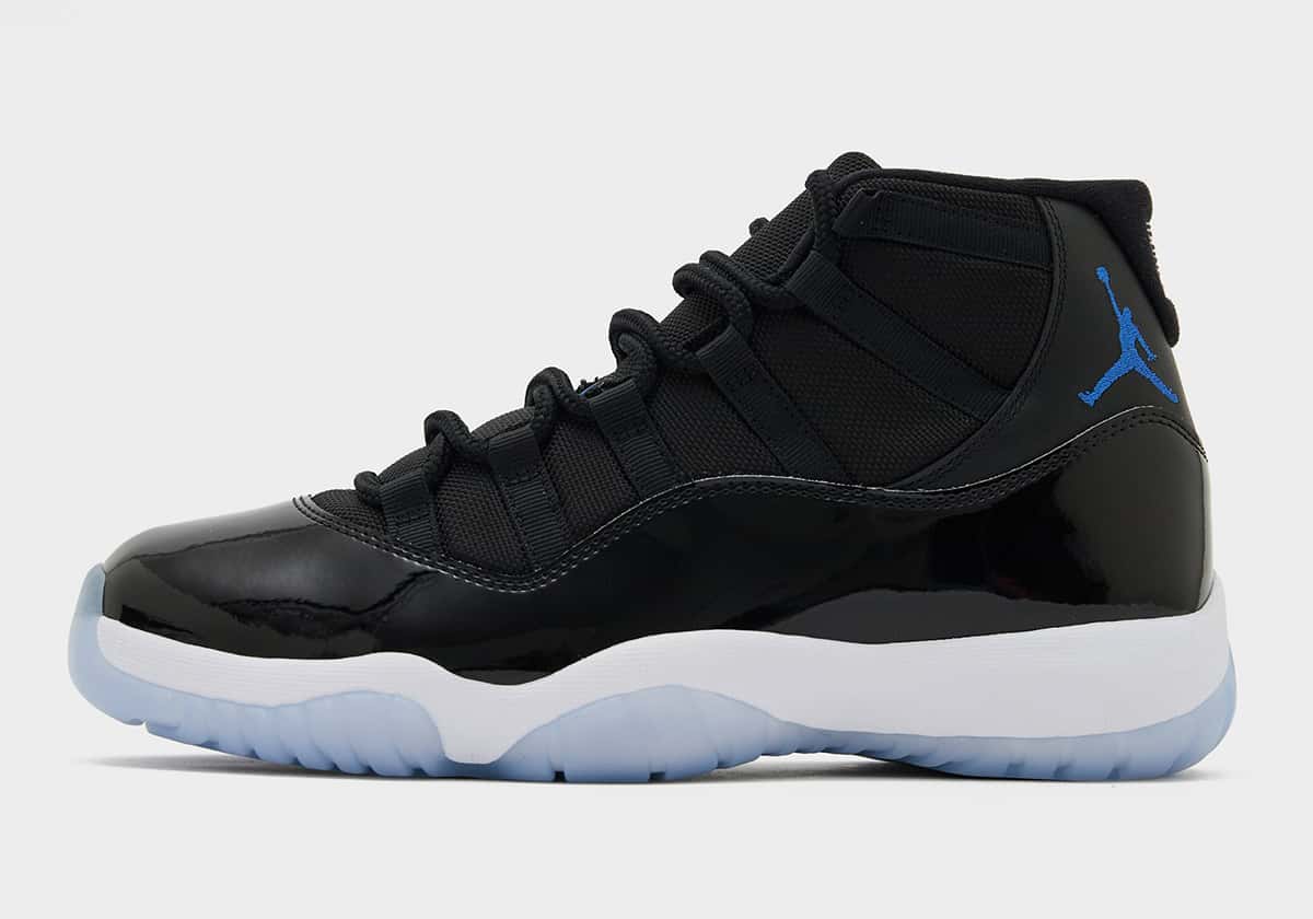 Air Jordan 11 Space Jam 2026 de perfil con charol negro, Jumpman Varsity Royal y suela translúcida