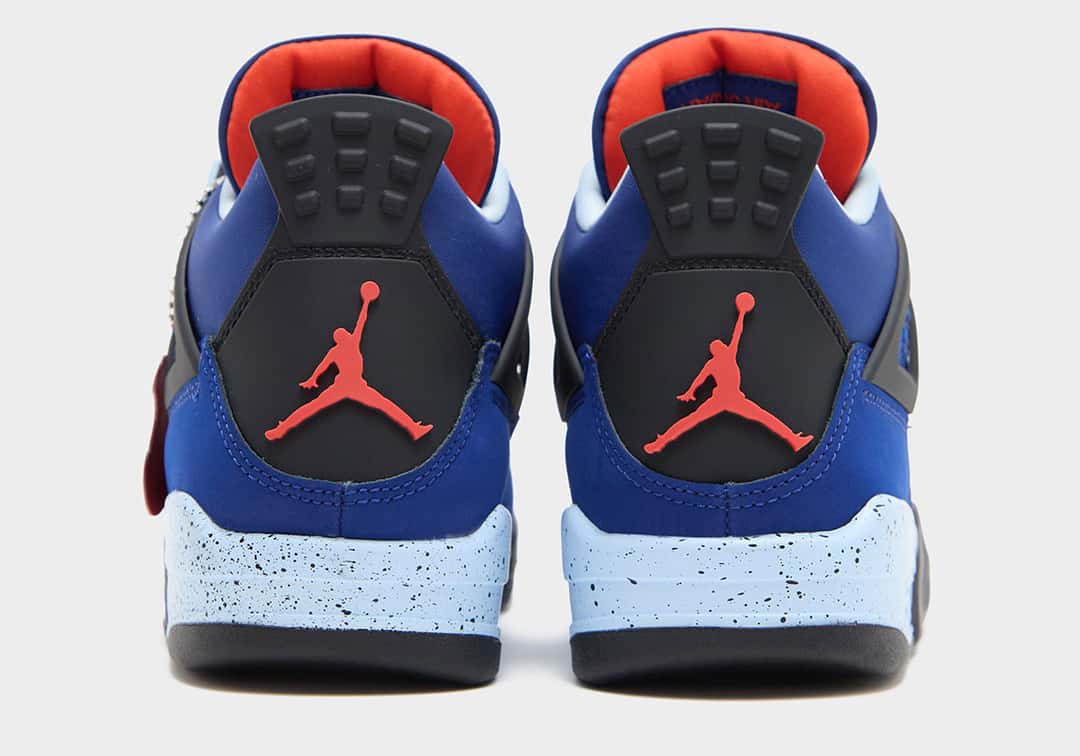 Talones del Air Jordan 4 Deep Royal Blue sobre fondo gris claro, con la pestaña negra, el Jumpman rojo, la entresuela celeste moteada y el interior en rojo