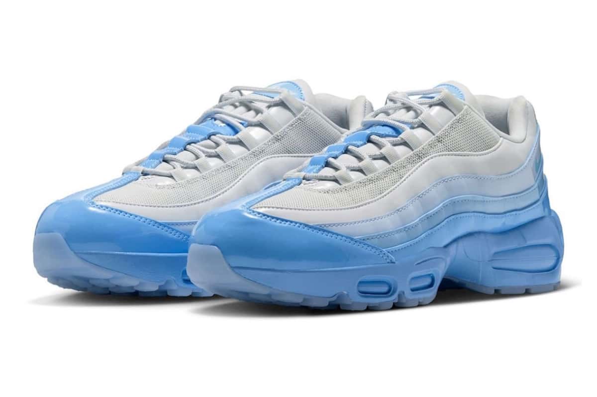 Par del Nike Air Max 95 Blue Tint en vista de tres cuartos sobre fondo blanco, con malla gris claro, capas laterales de charol en degradé hacia el celeste, puntera de charol celeste y suela translúcida