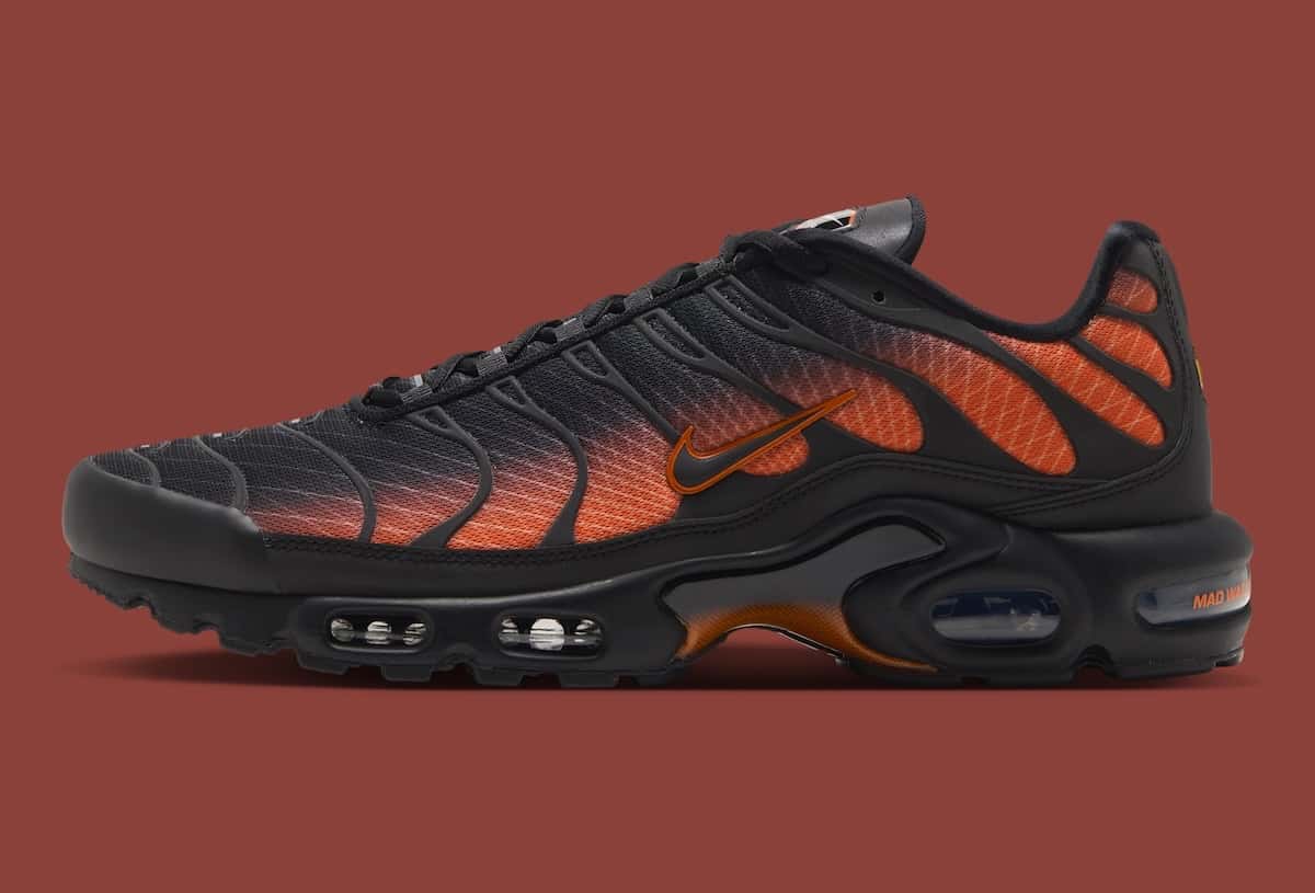 Nike Air Max Plus «Glasgow» de perfil, negra con degradé naranja en las líneas de la capellada, sobre fondo bordó