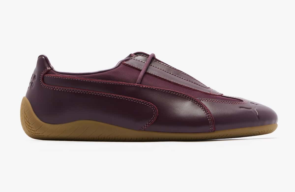 PUMA Speedcat Slip-On de Daniëlle Cathari de perfil sobre fondo blanco, con upper de cuero bordó amarronado, costuras a la vista, panel textil en el empeine y suela de goma gum