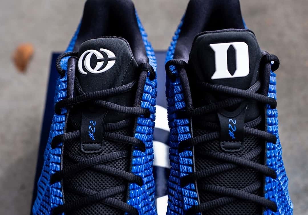 Lengüetas de la Nike Caitlin 1 PE de Duke, una con el logo CC y otra con la D de Duke en blanco, sobre los cordones negros