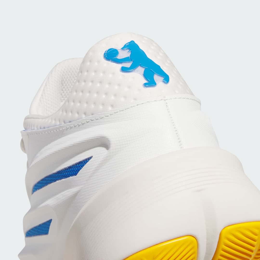Primer plano del talón de la adidas Crazy Energy Wagner Brothers, con un oso azul sosteniendo una pelota de básquet sobre el material blanco perforado y la suela amarilla asomando abajo