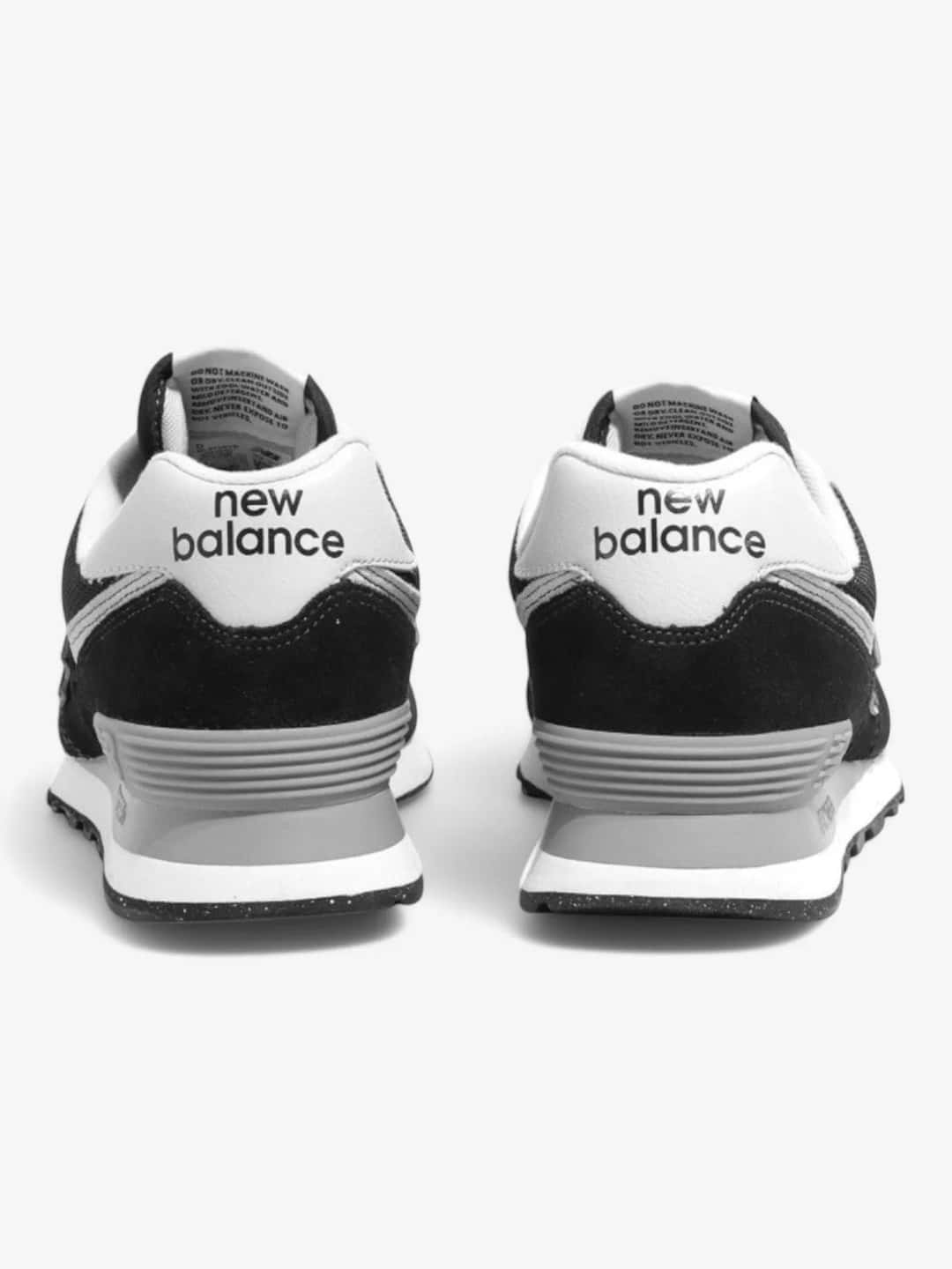 Vista trasera de unas New Balance 574 negras y grises con el logo de New Balance en el talón