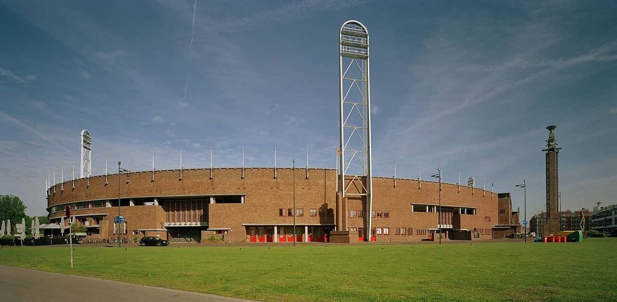 Foto de archivo: el Estadio Olímpico de Ámsterdam, de ladrillo, con su torre de luz y el campo de césped adelante, bajo un cielo azul con nubes