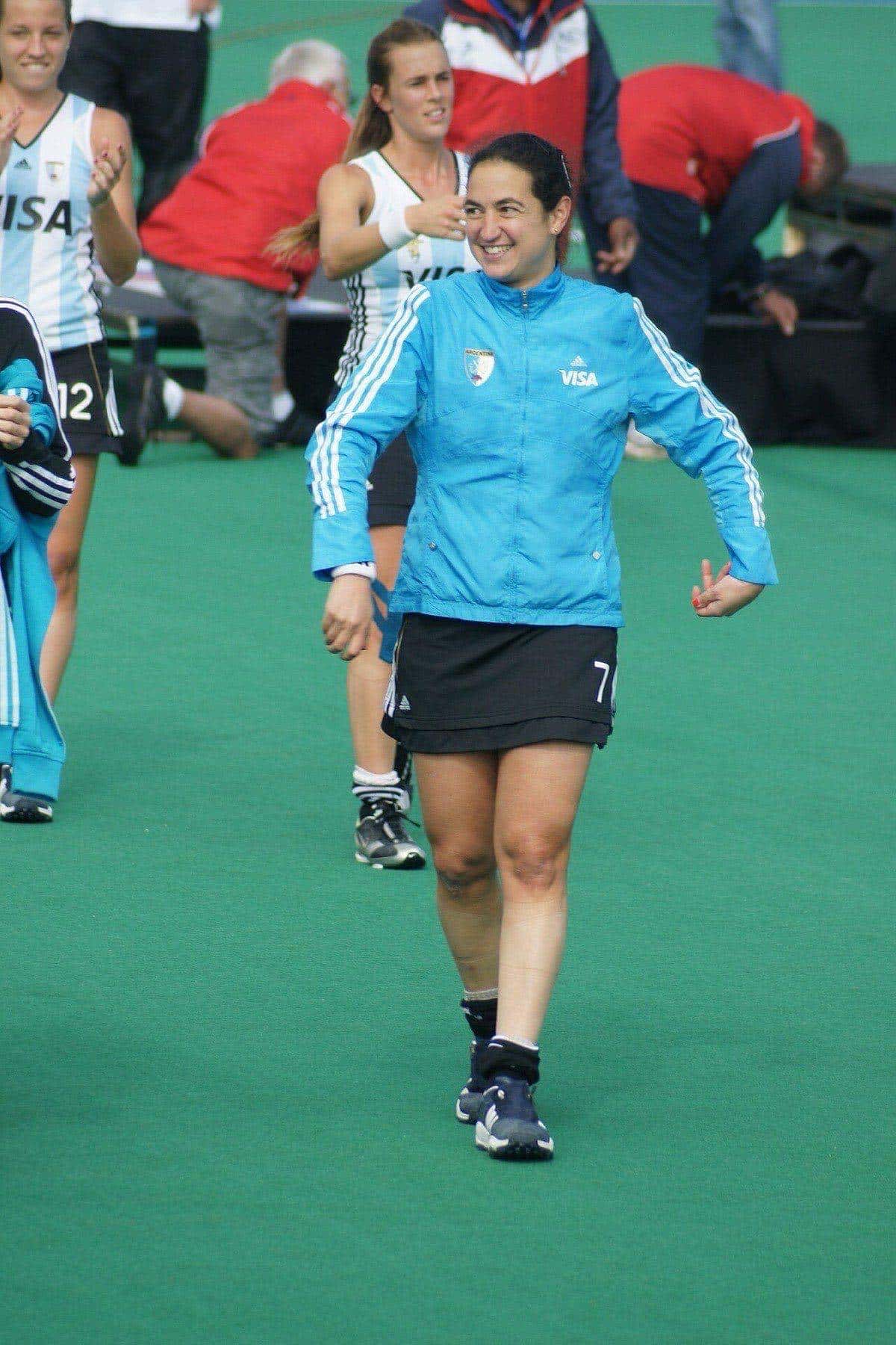 Foto de archivo: Alejandra Gulla, con campera celeste de la selección argentina y el número 7, sonríe en una cancha de hockey en 2009