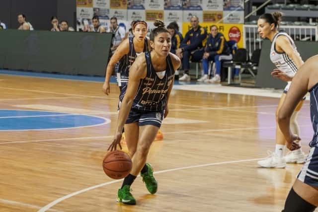 Una jugadora de Peñarol, con la camiseta azul y el número 1, avanza picando la pelota en el Polideportivo Islas Malvinas, con una rival de Boca de blanco a la derecha