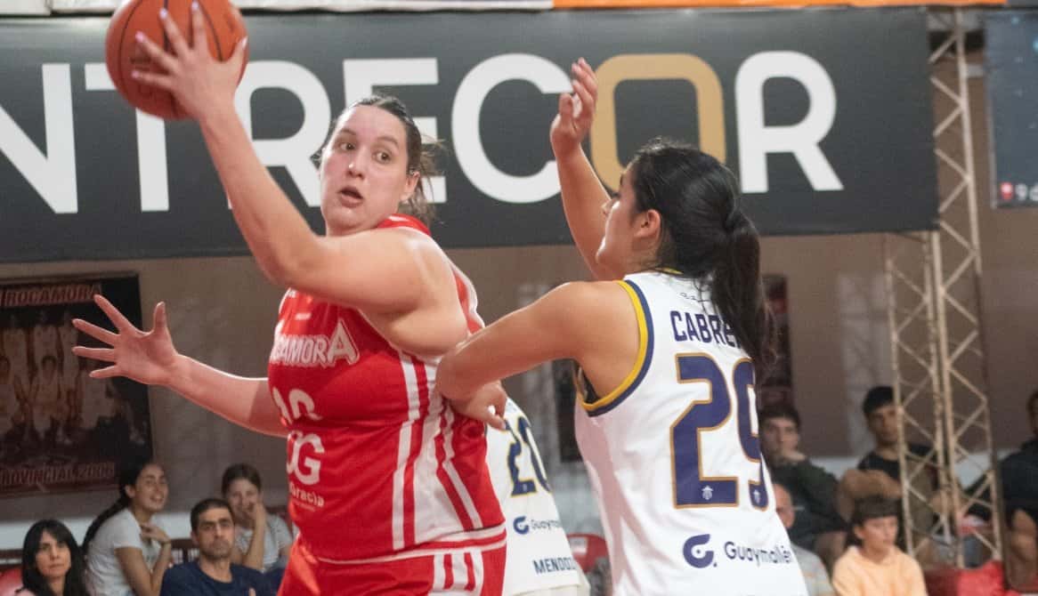 Una jugadora de Rocamora, con camiseta roja, protege la pelota en lo alto ante la marca de una jugadora de San José, con camiseta blanca número 29