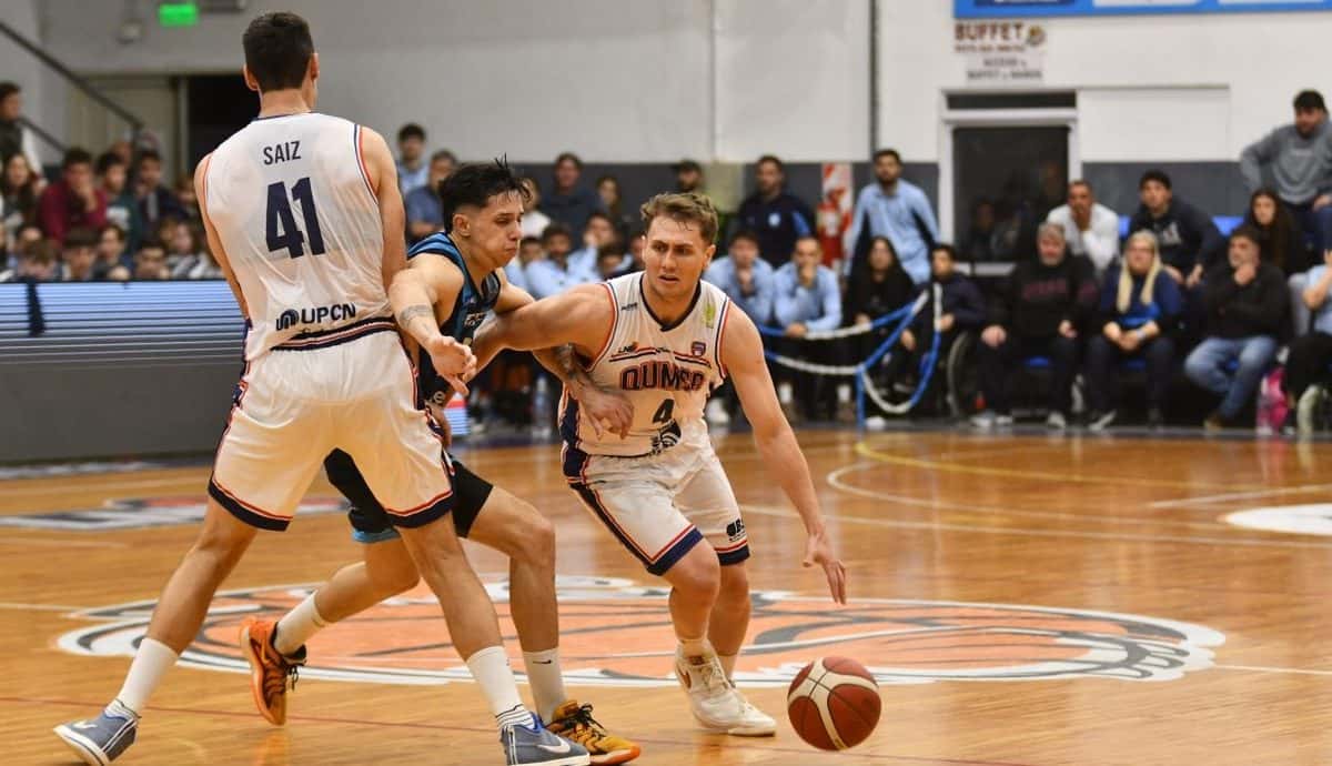 Un base de Quimsa, con la camiseta blanca número 4, avanza con la pelota entre jugadores de Racing de Chivilcoy en el Grilon Arena