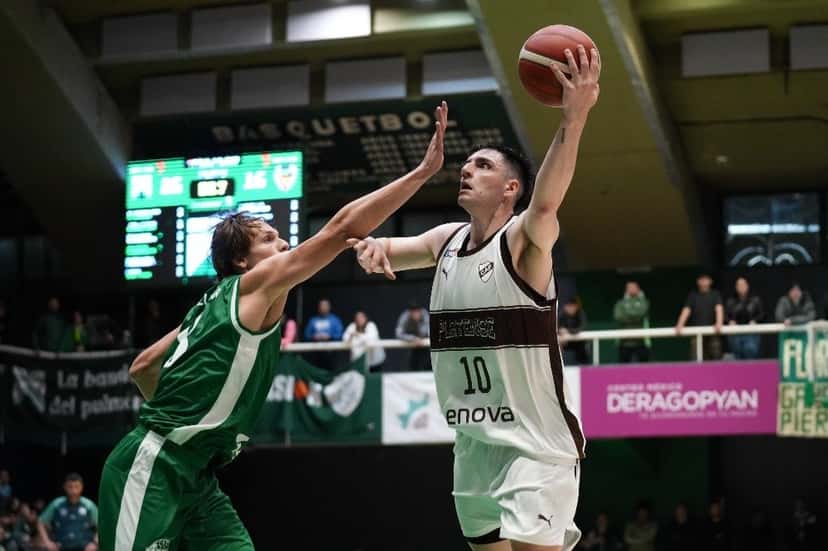 Un jugador de Platense, con la camiseta blanca número 10, levanta la pelota para tirar mientras un jugador de Ferro, de verde, intenta taparlo