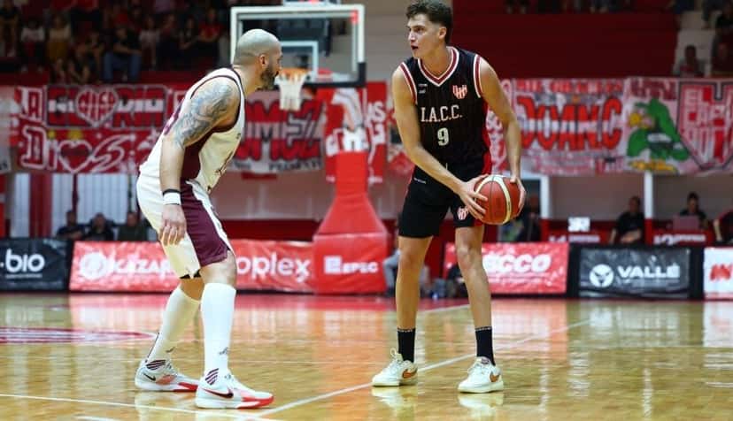 Un jugador de Instituto, de negro, conduce la pelota marcado por un jugador de Lanús, de blanco y granate, en La Caldera