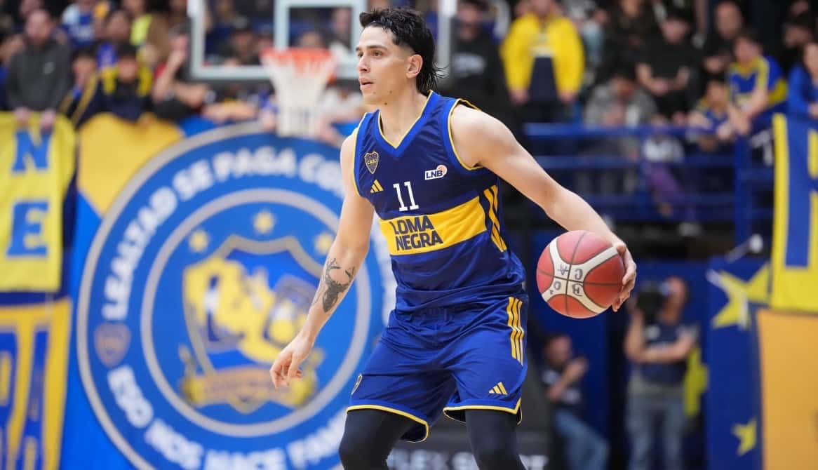 Un jugador de Boca, con la camiseta azul y amarilla número 11, avanza con la pelota en La Bombonerita, con las banderas del club detrás