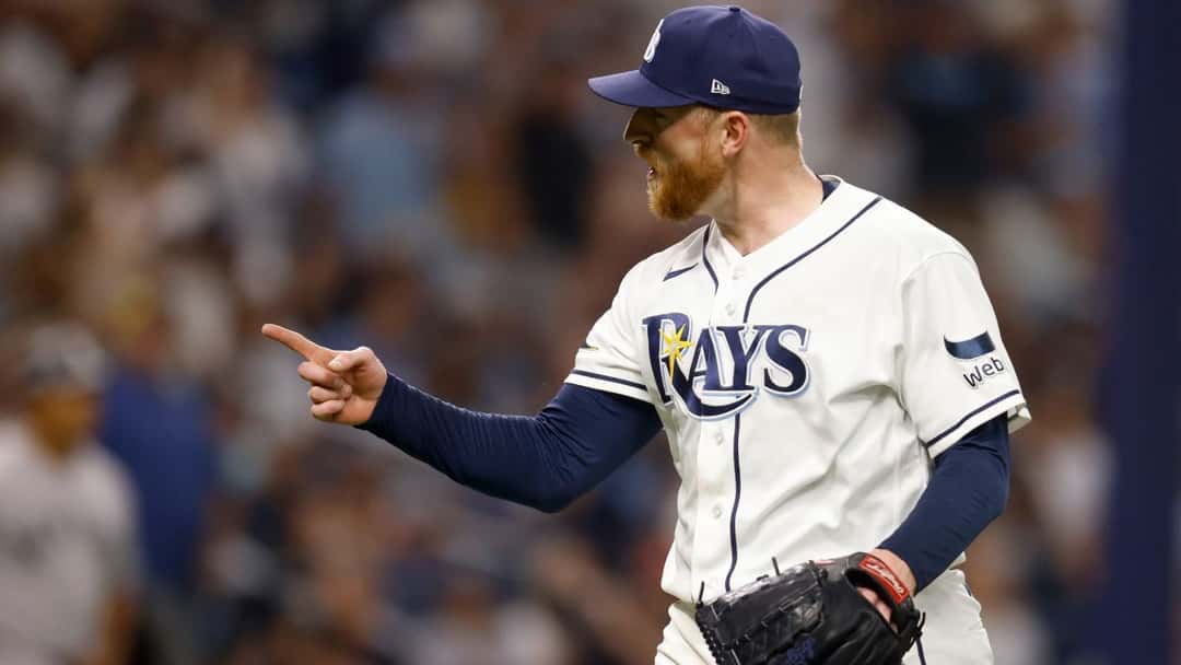 Un lanzador de los Rays, con la camiseta blanca de local, señala hacia el campo en Tropicana Field