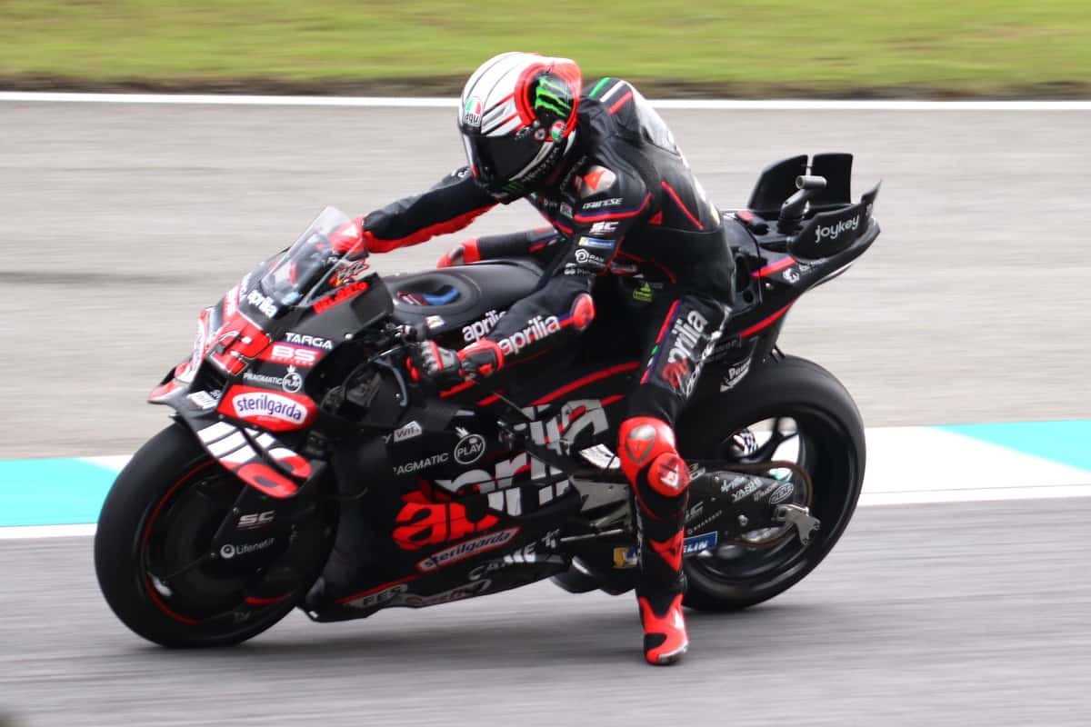 Foto de archivo: Marco Bezzecchi, con casco blanco y rojo, inclina la Aprilia negra y roja en una curva con pianos celestes y blancos