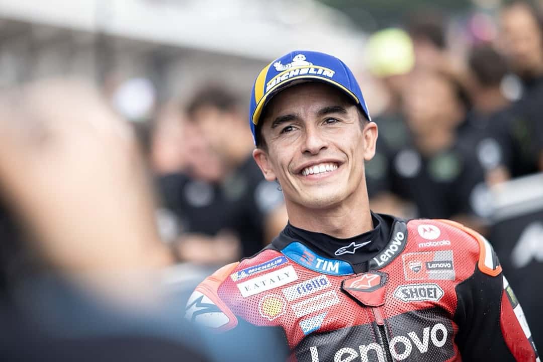 Foto de archivo: Marc Márquez sonríe con el buzo rojo de Ducati y la gorra puesta, rodeado de gente, en el Gran Premio de Alemania 2026
