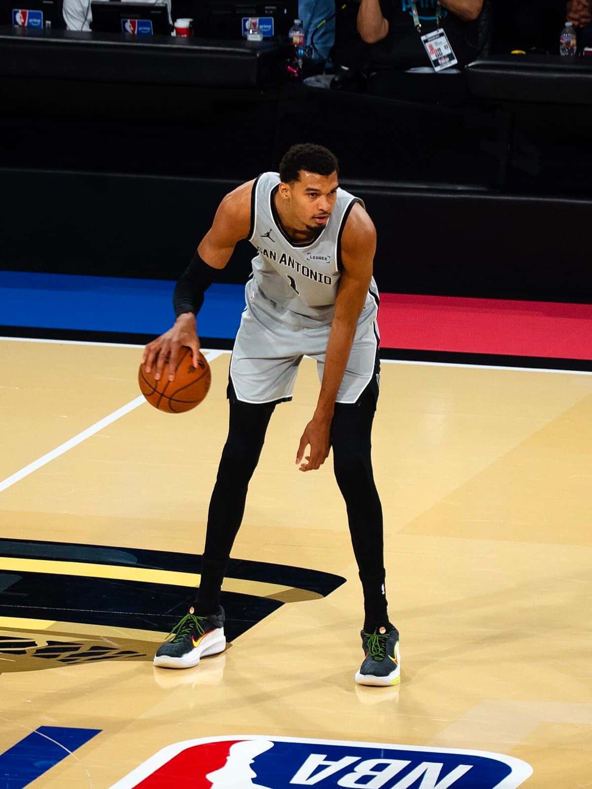 Foto de archivo: Victor Wembanyama, con la camiseta gris número 1 de los San Antonio Spurs, dribla la pelota durante un partido de la Copa NBA 2025