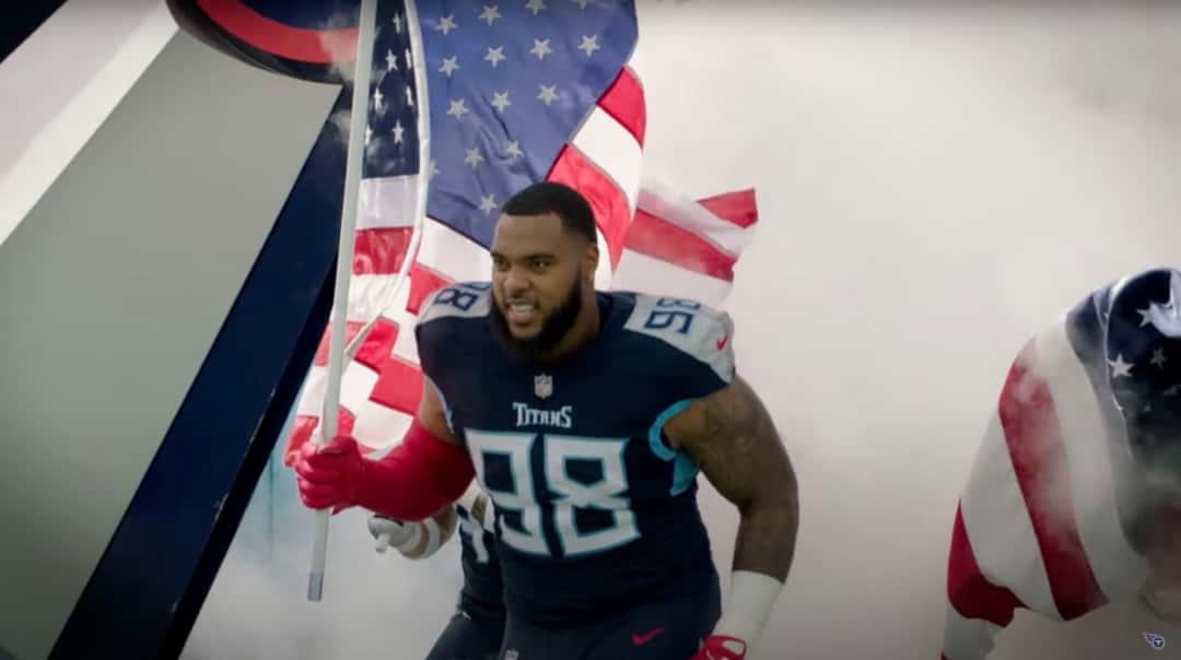 Foto de archivo: Jeffery Simmons, con la camiseta azul oscuro número 98 de los Titans, sale a la cancha con una bandera de Estados Unidos entre humo