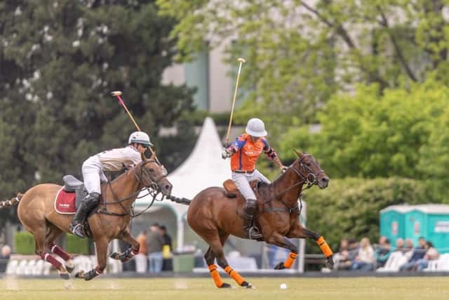 Un jugador de Las Monjitas, de naranja, y uno de La Aguada, de blanco, galopan detrás de la bocha en el Abierto de Tortugas