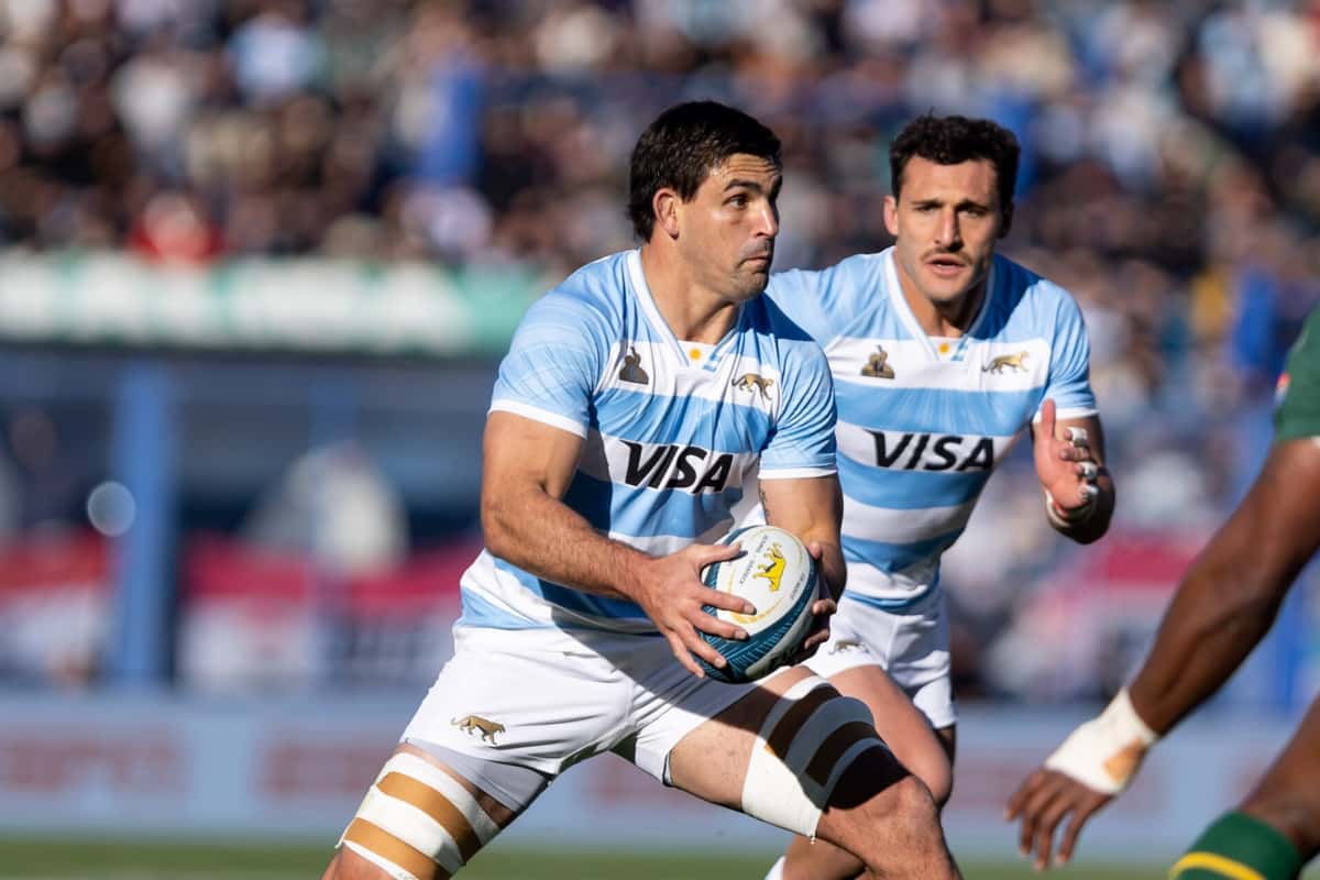 Foto de archivo: un jugador de Los Pumas, con la camiseta celeste y blanca, corre con la pelota en las manos ante Sudáfrica en el estadio José Amalfitani, con otro compañero detrás