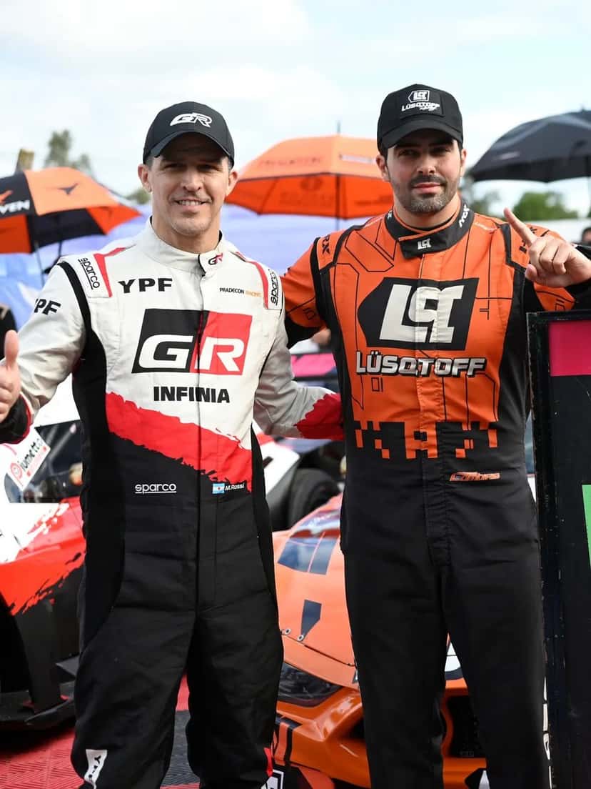 Matías Rossi, con el buzo blanco y rojo de Toyota, y Mauricio Lambiris, con el buzo naranja de su equipo, posan juntos en la grilla de Rosario antes de la final