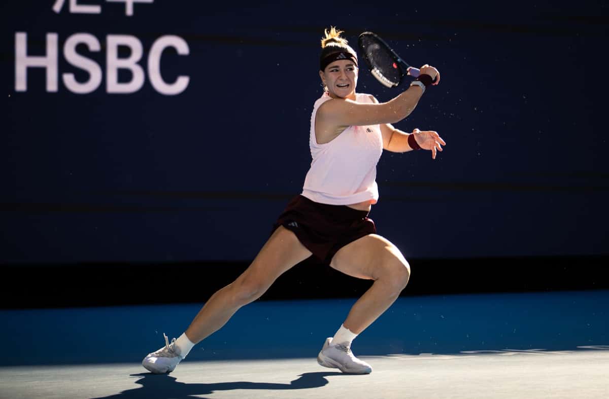 Karolina Muchova, con musculosa rosa clara, short bordó y vincha, pega un drive en su partido de octavos de final del China Open 2026 ante Naomi Osaka