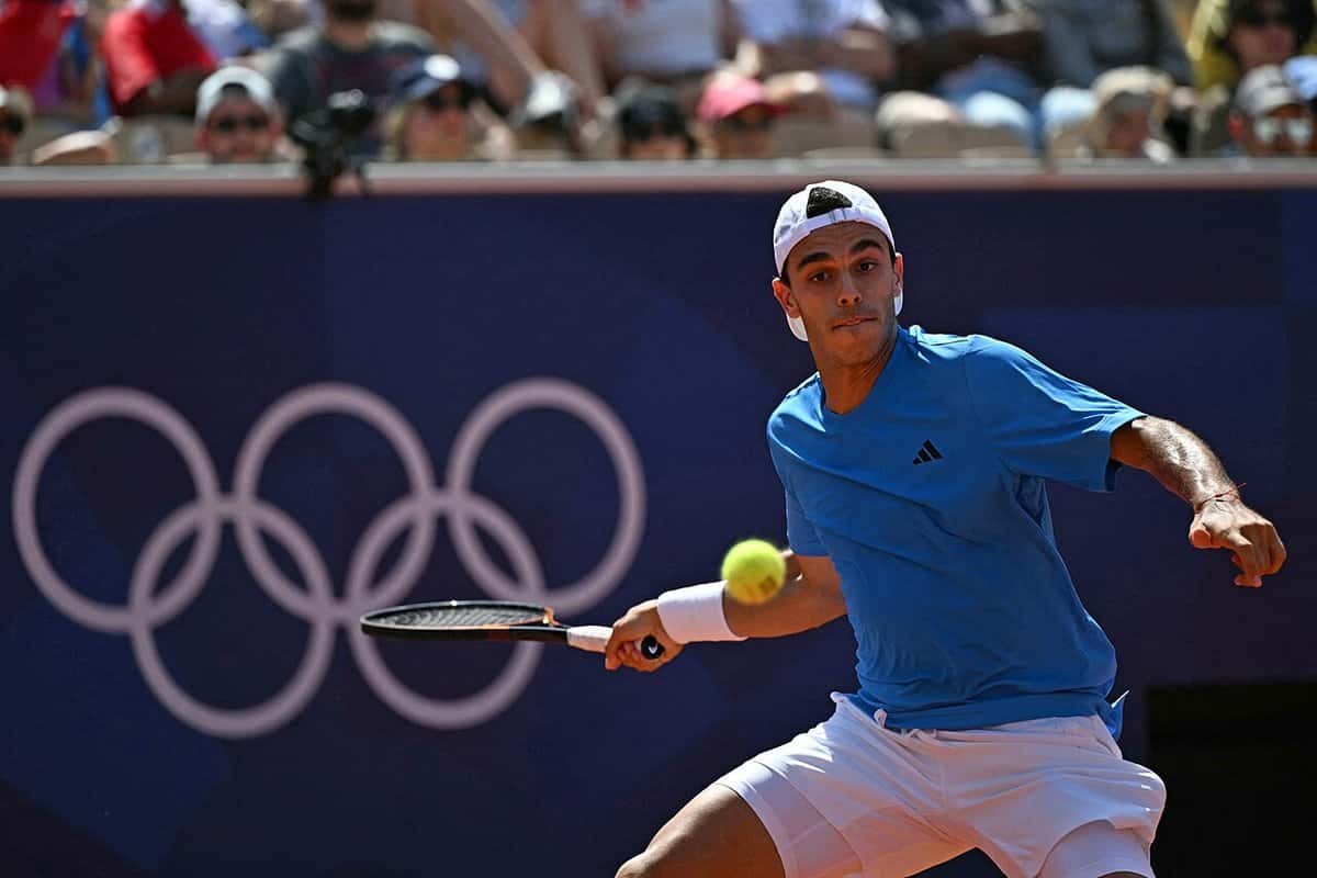 Foto de archivo: Francisco Cerúndolo, con remera azul y gorra blanca, le pega a la pelota en los Juegos Olímpicos de París 2024