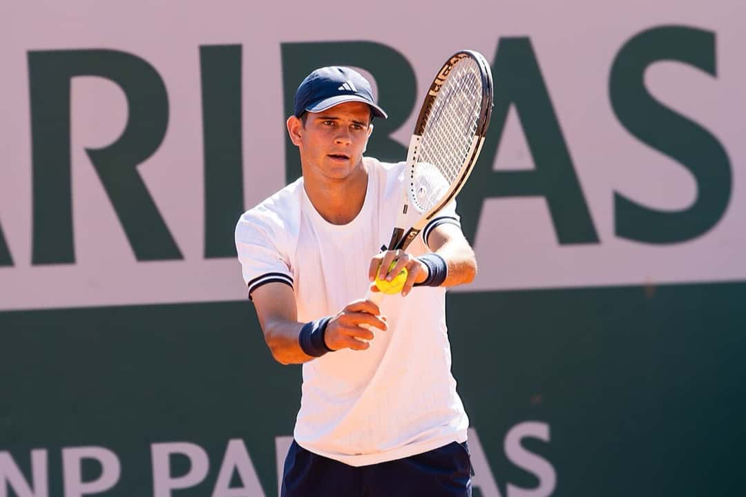 Foto de archivo: Rafael Jodar, con gorra azul y remera blanca, sostiene la pelota y la raqueta antes de sacar, delante de un cartel con letras verdes